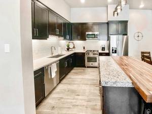 摩押Beautiful Brand NEW Luxury Condo @ Sage Creek的厨房配有黑色橱柜和木制台面