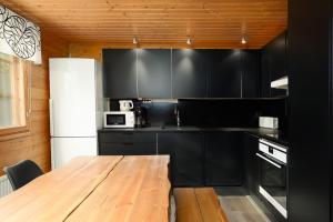 卡拉约基Villa Särkkä的厨房配有黑色橱柜和木桌