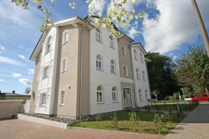 奥斯赛拜-塞林Villa Wilhelmine - Ferienwohnung 04 mit Balkon的街道上一座白色的大建筑