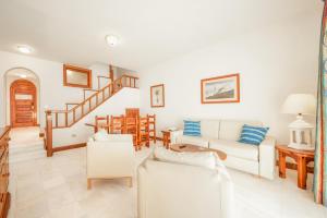 美洲海滩Parque Santiago III Official的客厅配有白色家具和楼梯