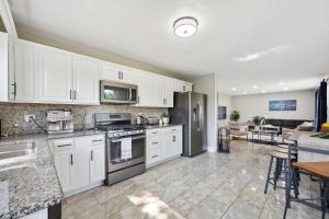 格伦维尤Charming Contemporary Family Home home的厨房配有白色橱柜和不锈钢用具