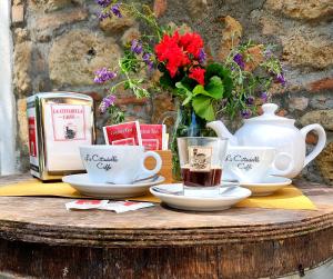 渥尔特拉Locanda Prato d'Era的茶杯,盘子,花瓶的桌子