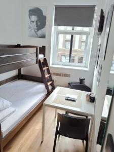 格丁尼亚蓝调客房旅舍的小房间设有双层床和桌子