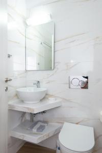 阿波罗尼亚Hotel Sofia的白色的浴室设有水槽和卫生间。