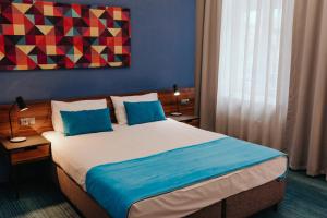 罗兹托巴克罗兹酒店的一间卧室配有一张带蓝色枕头的大床