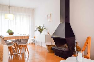 贝萨卢Can Falga Alojamiento en el corazón de Besalú的客厅设有壁炉和餐桌。
