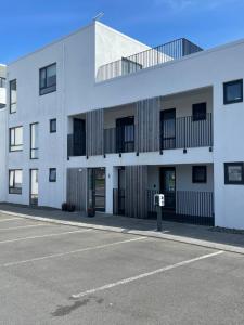 雷克雅未克Saga Apartments Reykjavík的白色建筑前的一个空停车位