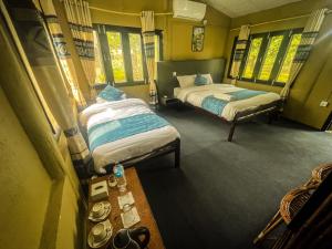 奇旺Hotel Tharu Garden And Beer Bar的小型客房设有2张床和窗户。