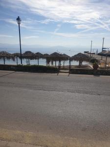 贝尼蔡斯Riviera Seaside Hotel的海滩上一条带稻草遮阳伞的空街道
