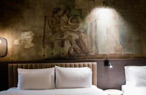 戈里察Vila Borgjeze的卧室配有白色枕头,床上方有绘画作品