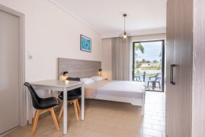 马尔马里安西亚公寓酒店的酒店客房带一张床、一张桌子和椅子