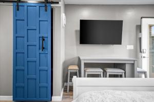 凤凰城Chelsea Place的一间带电视和蓝色门的卧室