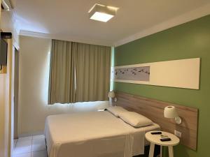 马塞约Hotel Porto Grande的酒店客房配有一张床铺和一张桌子。