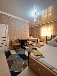 AralʼskГостиница NUR的一间卧室配有一张床、一张桌子和一张沙发