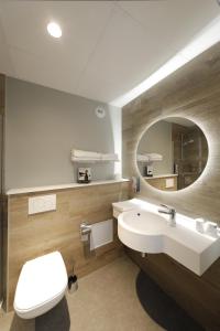 多勒Sure Hotel by Best Western Dole的一间带水槽、卫生间和镜子的浴室