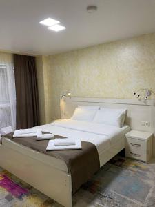 巴统Hotel Sonata的一间卧室配有一张大床和毛巾