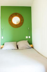 图卢兹Appartement Tolosa的一间卧室设有绿色的墙壁、一张床和镜子