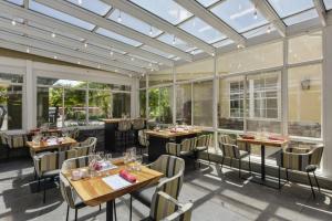 纳帕纳帕谷靛蓝酒店的餐厅设有桌椅和窗户。