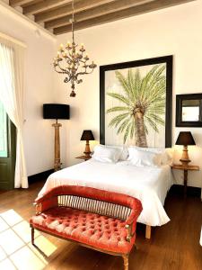 阿里亚Hotel Emblemático La Casa de los Naranjos的一间卧室配有一张大床和红色长凳