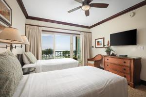 卡帕阿Waipouli Beach Resort and Spa Kauai by OUTRIGGER的酒店客房设有两张床和一台平面电视。