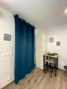 马赛Studio au calme.的一张桌子的房间里挂着蓝色窗帘