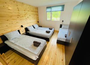 切尔诺莫雷茨CozyHut Бунгало под Наем的木墙客房的两张床