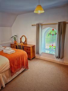 阿克斯明斯特The Old Chapel的一间卧室设有一张床和一个彩色玻璃窗