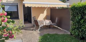 萨尔布吕肯Ferienwohnung Dachshübel的坐在院子里伞下的桌子和椅子