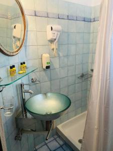 波尔塔里亚ΣΥΓΚΡΟΤΗΜΑ PALLADIO στο κέντρο της Πορταριάς的一间带绿色水槽和镜子的浴室