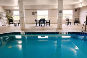 莫林卡尔森江山旅馆 - 莫林机场的大楼内一个带椅子和桌子的游泳池