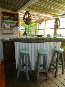 凯博波洛尼奥Carmela Cabo Polonio的户外酒吧前面设有两个绿色凳子
