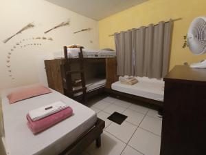 戈亚斯州上帕莱索Hostel do Gui的客房设有两张床、一张书桌和风扇