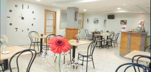 比利亚隆加Habitaciones Ninfa的一间带桌椅和红花的餐厅