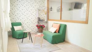 比利亚隆加Habitaciones Ninfa的客厅配有两张绿色椅子和一张桌子