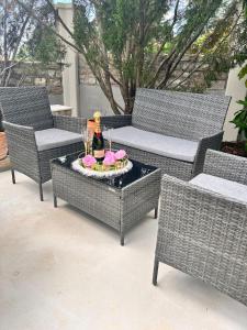 普拉Villa M.COCO的庭院设有藤椅和一张桌子及一瓶香槟