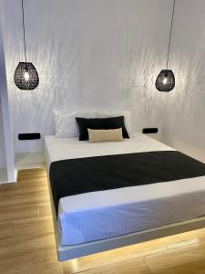 纳乌萨Asteras Cozy Stay的卧室配有一张带两个灯的大白色床