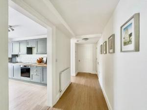 托基Lincombe Court Apartment Wellswood Torquay的厨房配有白色橱柜和硬木地板。