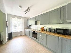 托基Lincombe Court Apartment Wellswood Torquay的厨房配有灰色橱柜和台面