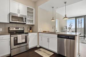 亚特兰大Piedmont Park 2 bdrm的厨房配有白色橱柜和不锈钢用具