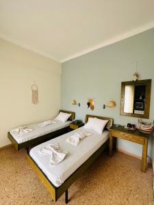 波罗斯Ancora Hotel的配有一张桌子和镜子的客房内的两张床