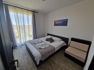 茨雷沃Arapya Apartments的卧室配有床、椅子和窗户。