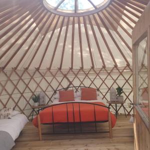 塔洛The Lawn Yurt的蒙古包内带床的房间,带窗户