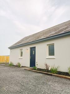 杜林The Cottage - Fairwinds的白色的房子,有蓝色的门