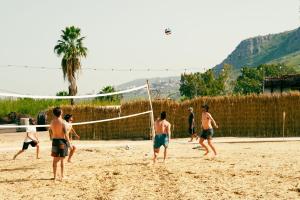 马格达拉Selina Kinneret的一群人在沙滩上打排球