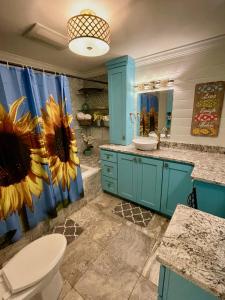 格兰德艾尔布鲁多菲乡村别墅的浴室设有蓝色橱柜和向日葵淋浴帘