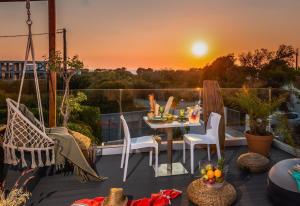 克雷马斯蒂Antonakis Villa, Near Beach, Private Pool的阳台配有桌椅,享有日落美景。