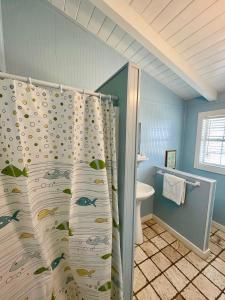 格兰德艾尔布鲁多菲乡村别墅的浴室设有淋浴帘,上面有鱼