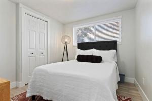 South Salt LakeAmazing New Condo Great Location ! Sugarhouse的白色的卧室设有一张白色大床和一个窗户。