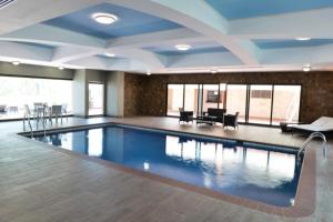 特古西加尔巴胡安卡洛斯广场酒店的一个带蓝色天花板的大型游泳池和一间客房