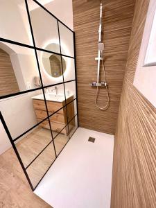 MollégèsMaison de charme avec Jacuzzi的浴室设有玻璃墙淋浴和水槽